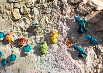 Colorful ceramic decorations add charm to an outdoor stone wall.