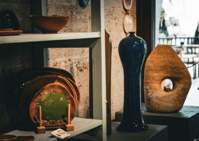 Showcase of artistic ceramic vases and plates in a rustic indoor setting.